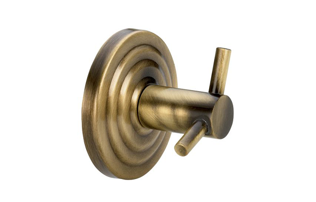 A bronze double hook bathroom accessory, likely made of brass or a similar alloy, with a textured circular backplate and two vertical hooks.