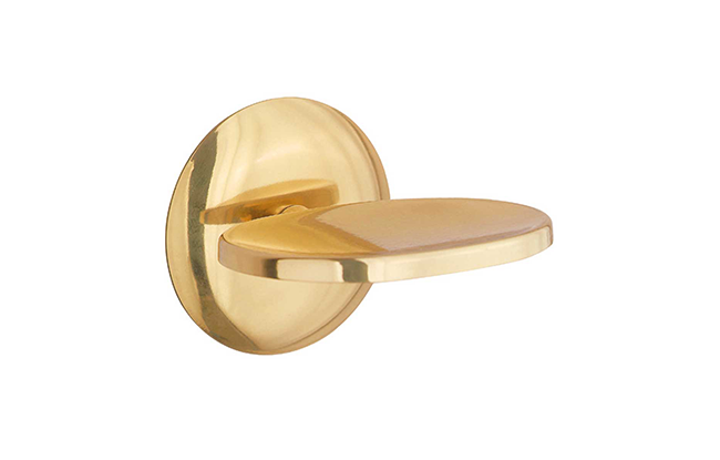 A gold-colored metal soap dish holder mounted on a wall.