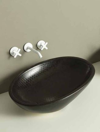 A black, oval-shaped bathroom sink with a modern design, accompanied by wall-mounted faucets. Vitruvit BLACK PYTHON designer washbasin – black ceramic sink for modern luxury bathrooms