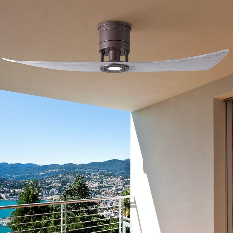 A textured bronze two blade ceiling fan by Lindsay, with the blade finish option shown as barn wood. The fan is positioned against a white background with the logos of Matthews and Atlas at the top.