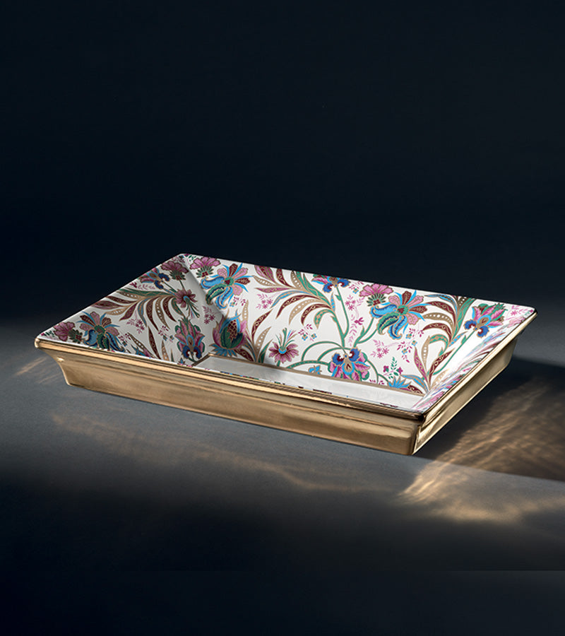 A luxurious ceramic bathtub with ornate floral patterns in gold, pink, and blue colors.