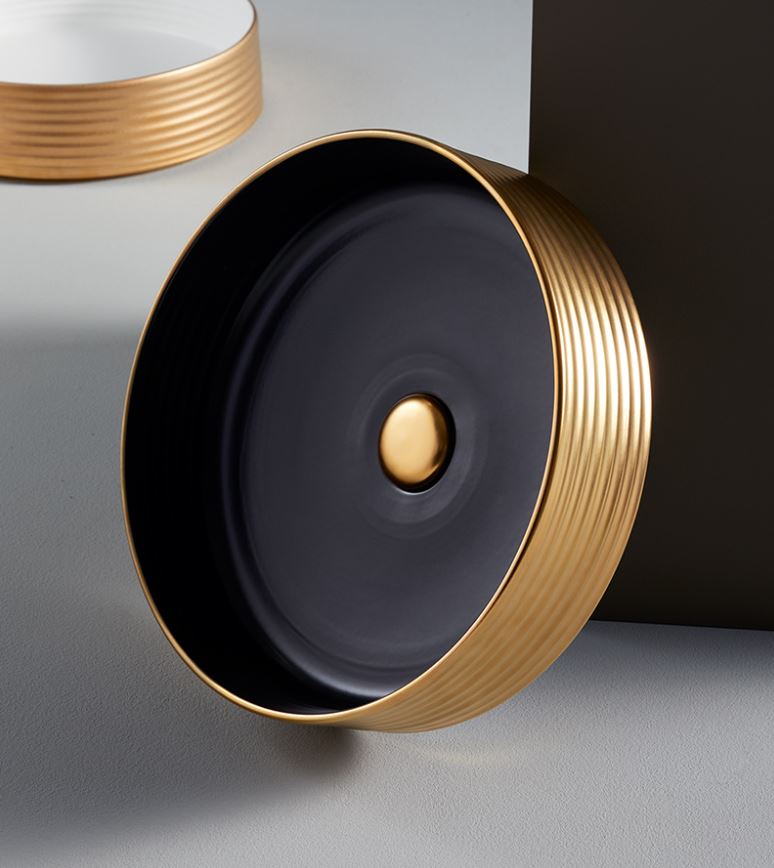 A black matte washbasin with a gold exterior, featuring a round shape and a central drain.