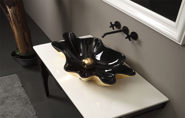 A modern washbasin with black and gold color scheme, displayed in a bathroom setting.